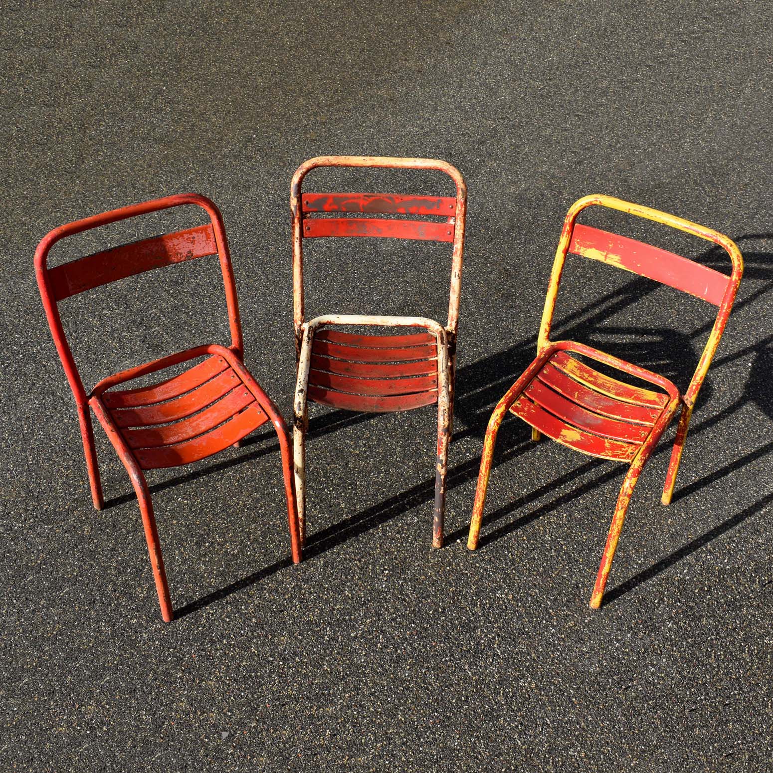 3 chaises de terrasses de bistrot dépareillées. Probablement de marque Tolix, type T1 et T2, (une ou 2 lattes sur le dossier). En état d’origine