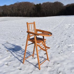 Vieille chaise haute de bébé en bois. Vintage des années 1970. En bois naturel, transformable en chaise bureau à roulettes.
