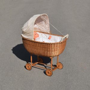 Ancien berceau dit Moïse, en osier des années 1950, avec couffin. Gros modèle pour bébé, avec auvent pliant en toile, et roulettes en bois.