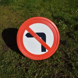 Panneau interdit de tourner à gauche, en tôle émaillée. Avec bordure en relief. Produit par signaux Girod en 1975. Diamètre 45 et épaisseur 2,7cm.