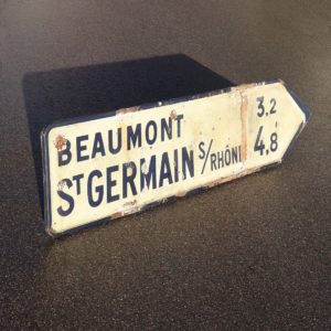 Old French road sign fifties with patina vintage deco year 1956. Ancien panneau routier d'origine Française daté de 1956. Beaumont St-Germain-sur-Rhône.