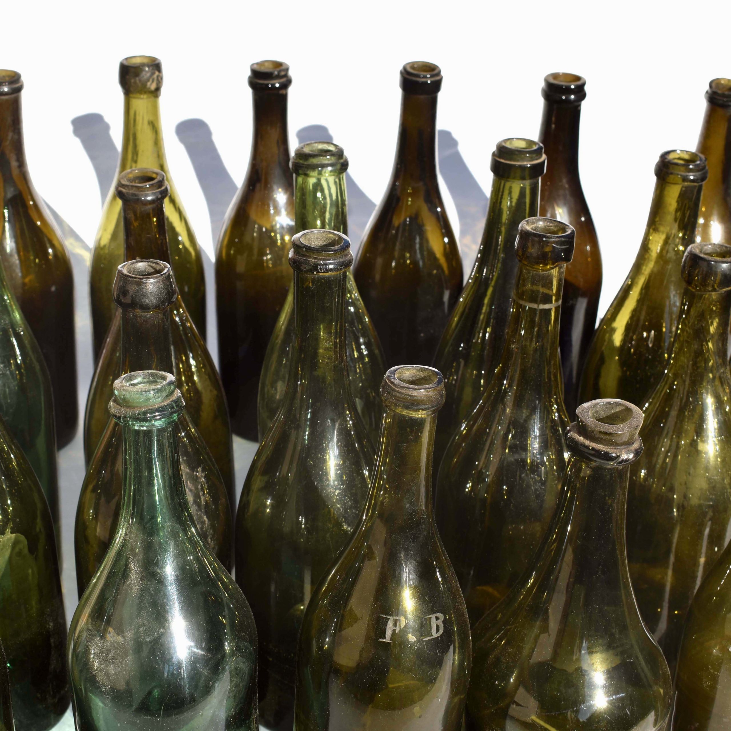 Anciennes bouteilles de vin en verre soufflé avec goulots irréguliers. Flacons pour le vin en verre vert, réalisés de manière artisanale, soufflé à la bouche.