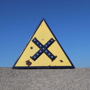 Panneau de signalisation routière française de danger de croisement. Des années 1930, en relief, avec trous pour billes de catadioptres. Fond émaillé jaune, avec bordure et dessin bleu