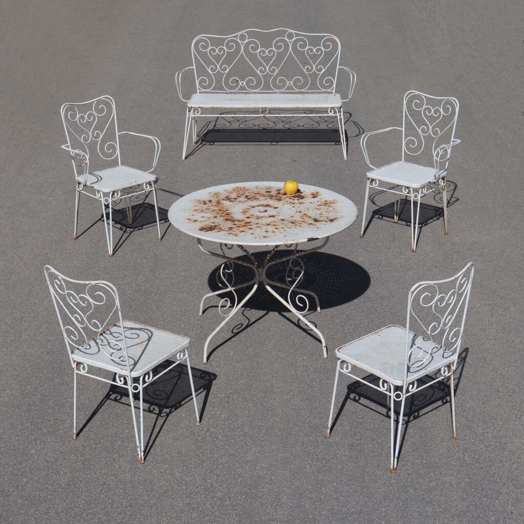 Salon de jardin 60s romantique. fer forgé avec décor de volutes.