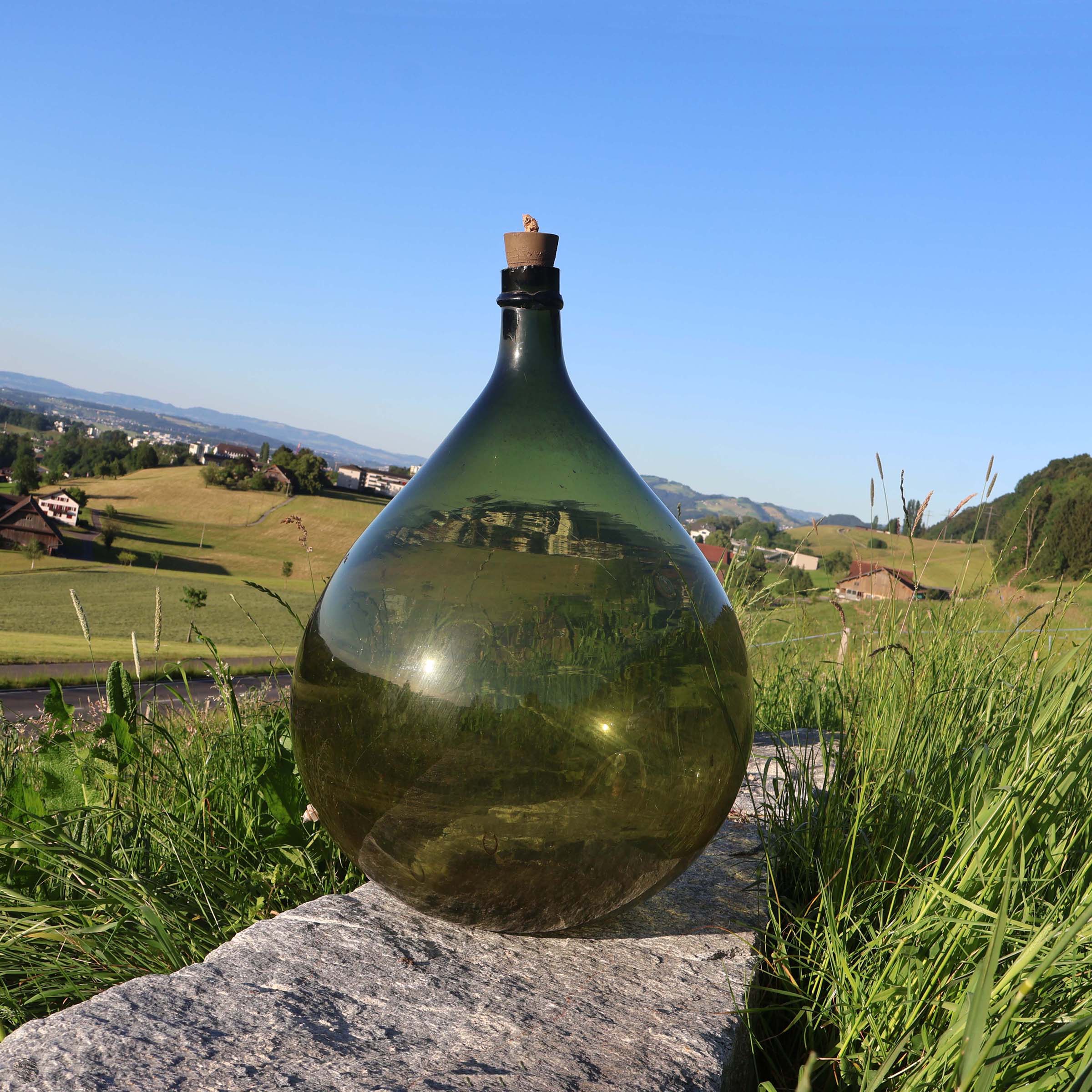 Grande bonbonne dame-jeanne. En verre vert.