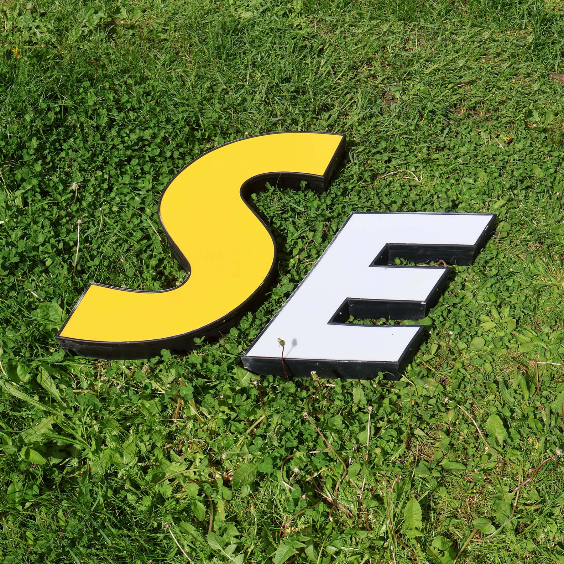 Lettres d'enseigne vintage S E. Majuscules italique.