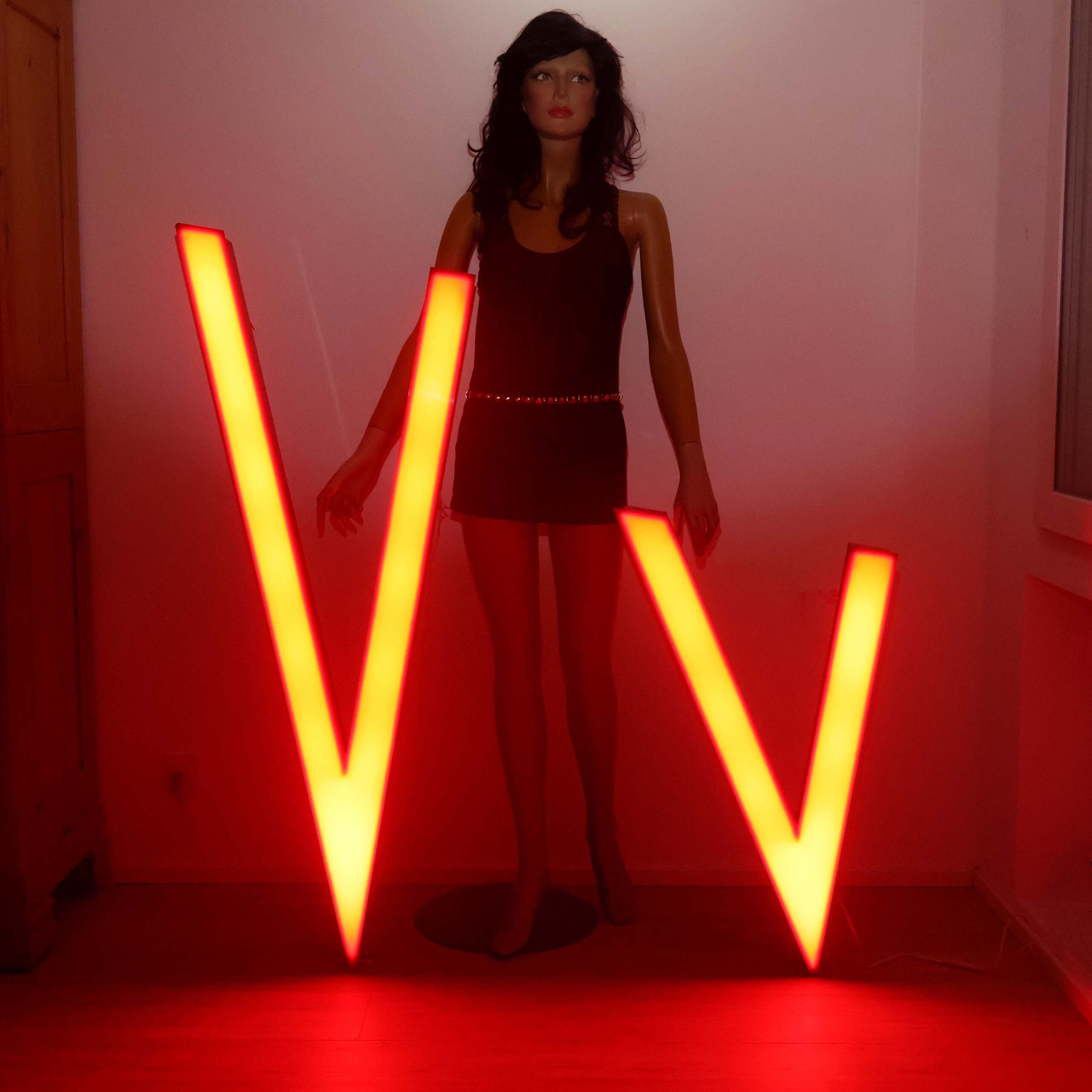 Grands V lumineux rouges LED. Déco intérieure avec objets